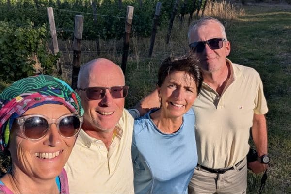 4 Freunde Arm in Arm vor den Weinreben