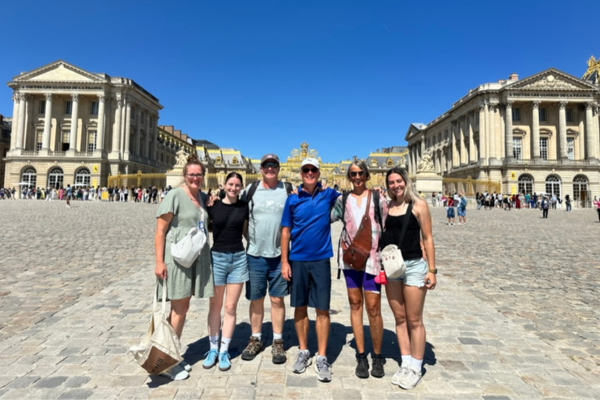 6 Personen stehen zusammen vor dem Eingang nach Versaille