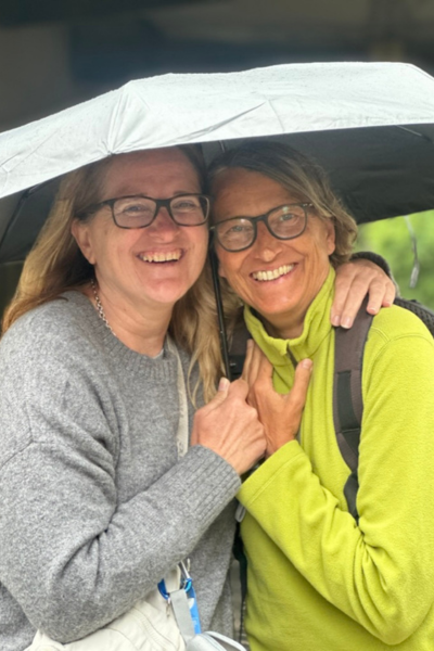 Meine Freundin Bernita und ich gehen im Regen mit Regenschirm spazieren