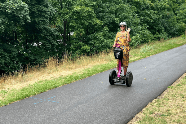 Ich fahre auf einem Segway und winke dem Fotografen zu